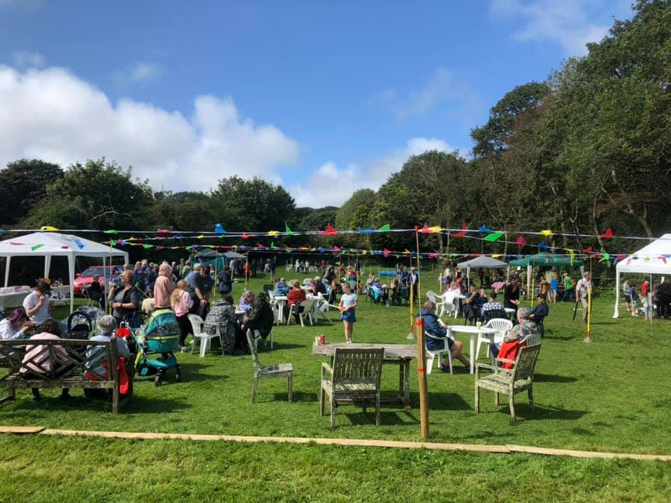 Summer fete with bunting and crowds enjoying the day