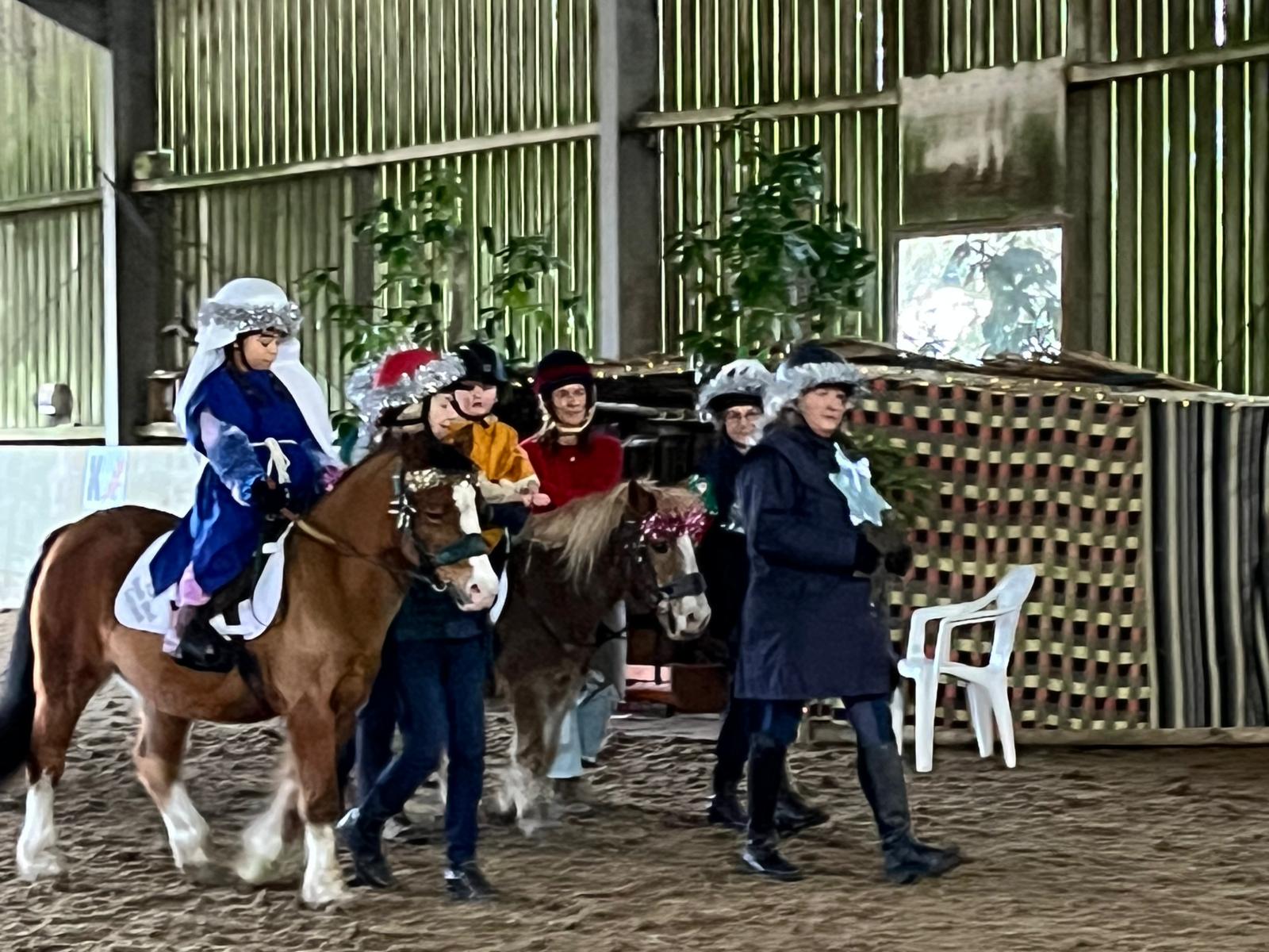 Riders, volunteers and ponies celebrating at a previous Christmas party